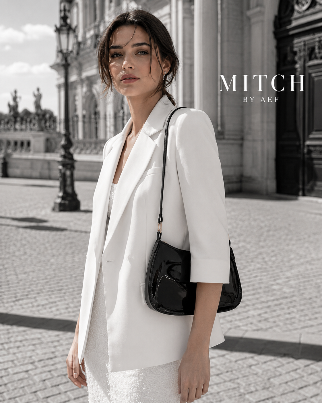 Sac noir verni porté à l’épaule par une femme en tenue blanche élégante à Paris #Mûre Noire