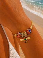 Bracelet jonc talisman doré charmes abeille strass multicolores perles rouges bleues, poignet bronzé plage