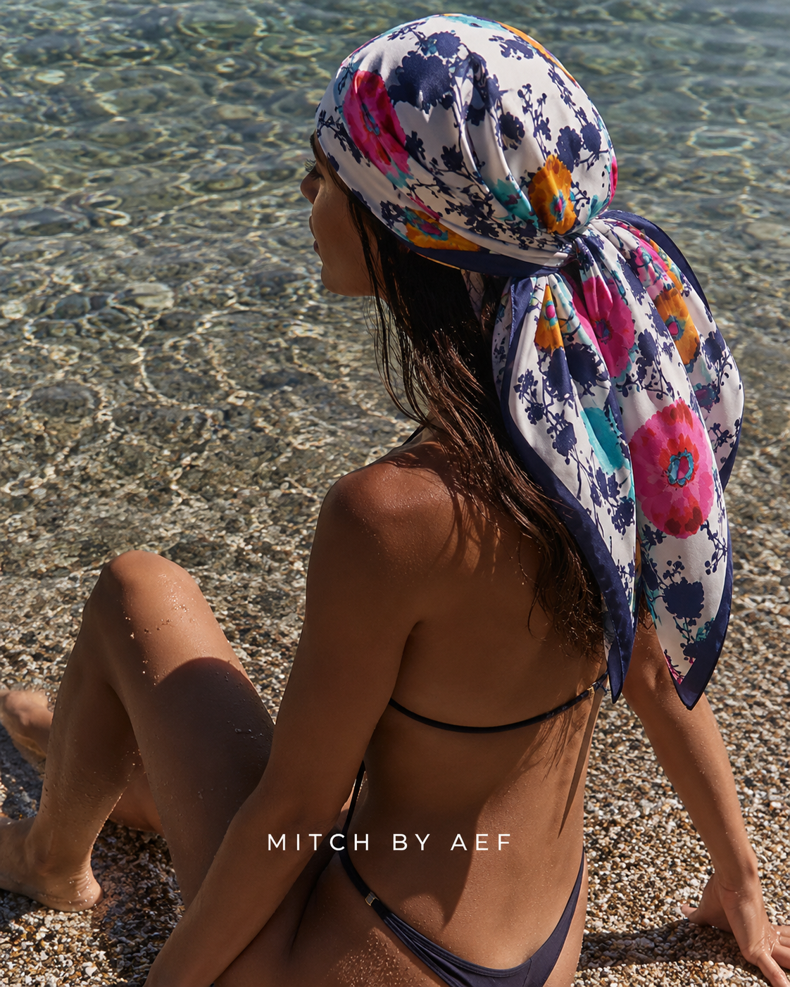 Foulard carré en satin pour femme POSITANO à motif floral multicolore, porté sur les cheveux à la plage
