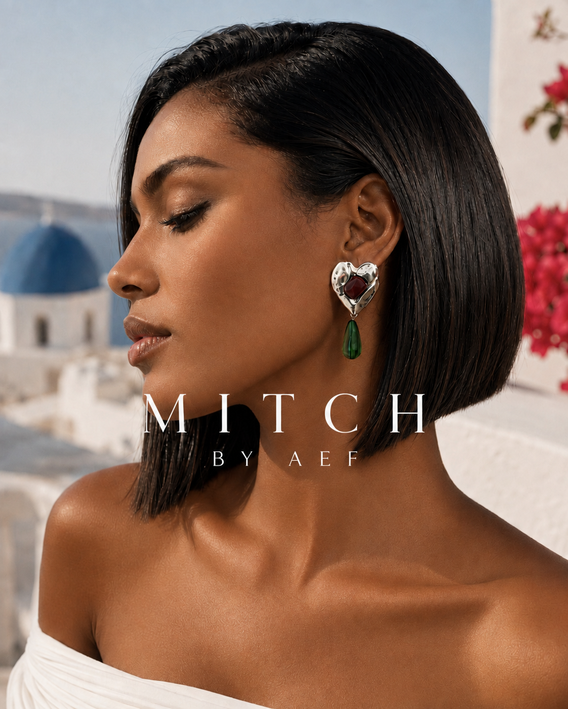 Boucles d’oreilles NÉA géométriques argentées avec cœur martelé, pierre bordeaux et pendentif vert, portées par une femme en lumière solaire dans un décor inspiré de Santorin – MITCH par AEF #Argenté