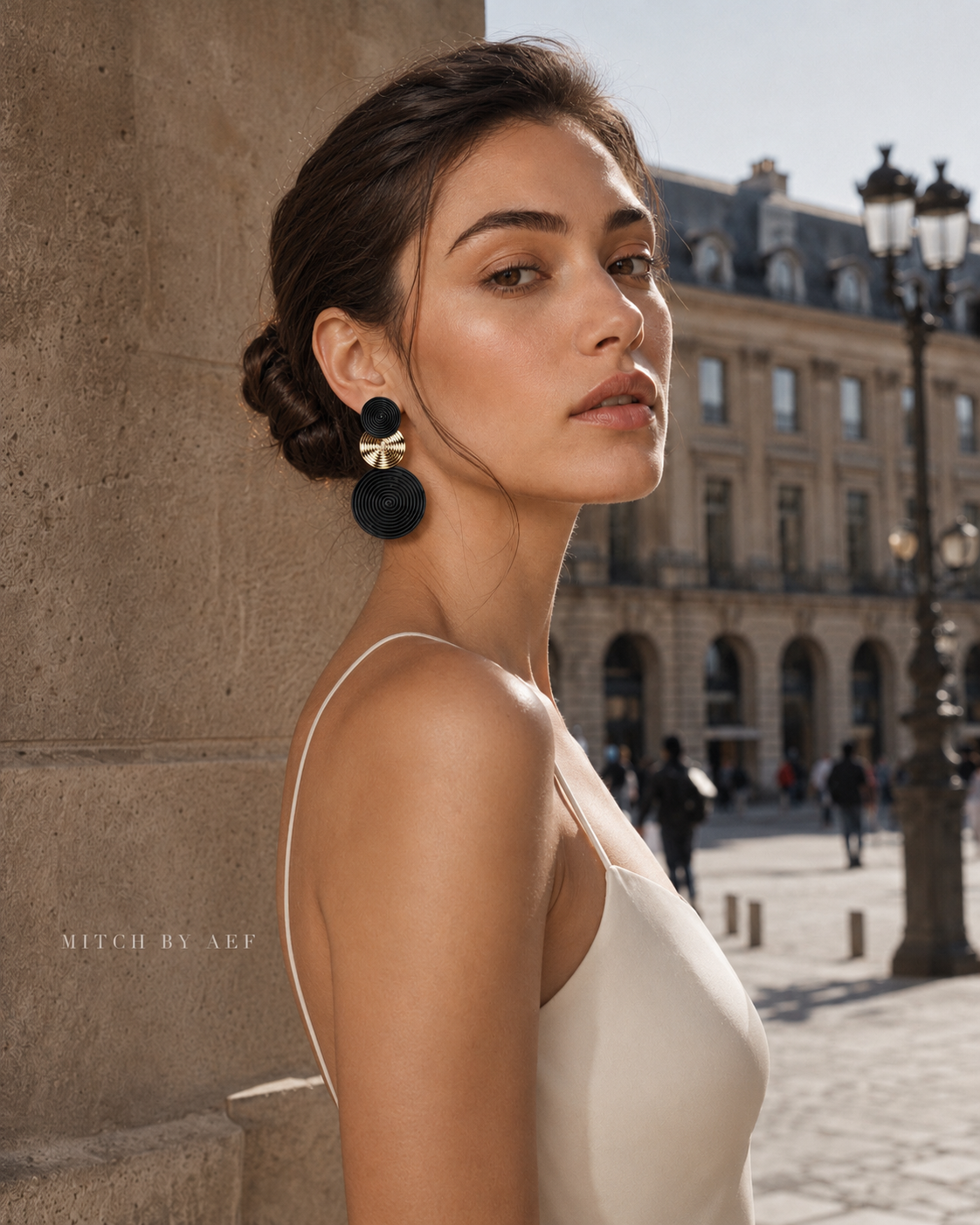 Boucles d’oreilles ORBIS noir et doré à trois disques graphiques portées par une femme