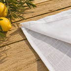 Détail ourlet et doublure robe longue blanche, couture finition visible, tissu extérieur semi-transparent et doublure intérieure, fond bois naturel citrons frais