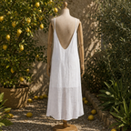 Robe longue blanche dos nu bretelles spaghetti sur mannequin bois, jardin méditerranéen citronnier et oliviers, zone transparente bas de robe visible, lumière naturelle chaude