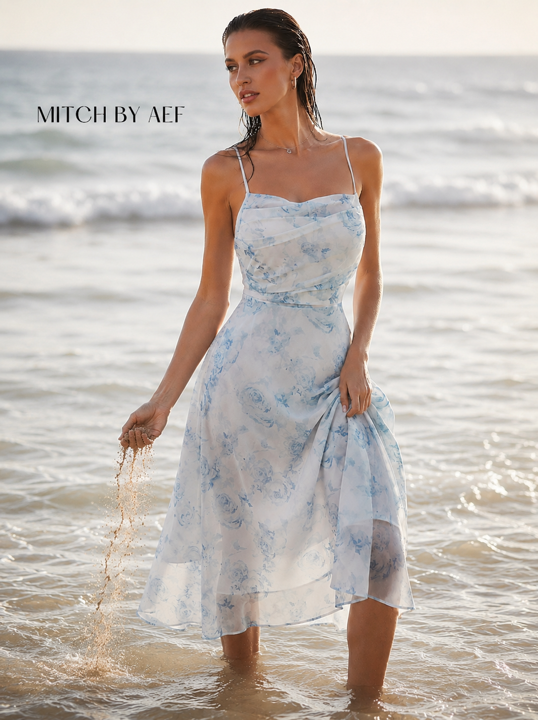 Robe mi-longue florale bleue et blanche bretelles spaghetti portée en bord de mer
