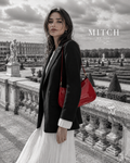Sac rouge verni porté à l’épaule avec blazer noir dans les jardins de Versailles #Cerise Fatale
